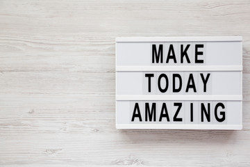 'Make today amazing' words on a modern board on a white wooden surface. From above, overhead, flat...