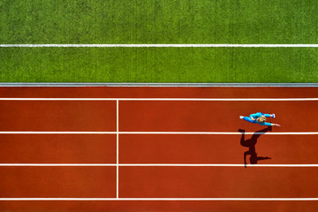 Obraz premium Athletic blonde woman running at open stadium