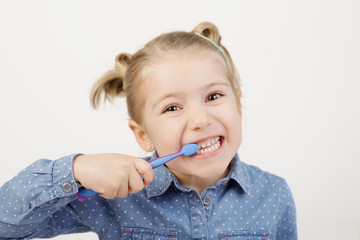 Cute little girl brushing her teeth, learning dental care at a young age.