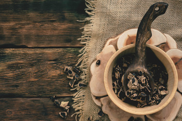 Dryed carob tree bark in a wooden bowl on a table.
