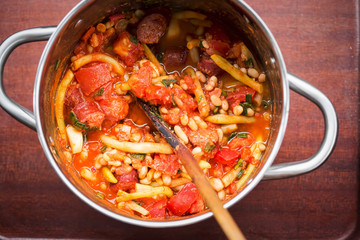 Fried sausage with beans, tomatoes, garlic in tomato sauce 