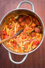 Fried sausage with beans, tomatoes, garlic in tomato sauce 