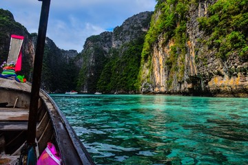 Long tail boat in thailand blue water with mountains on background 