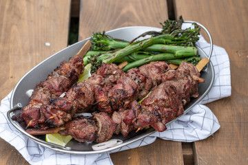 Grilled lamb meat kebabs with green broccolini