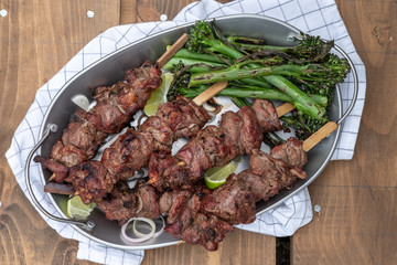 Grilled lamb meat kebabs with green broccolini