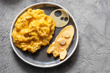 Kids funny breakfast with scrambled eggs, cheese and tortilla rocket