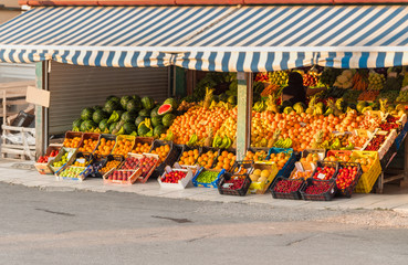 local neighborhood fresh summer fruit market with colorful organic fruit on display in greece