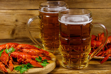 Boiled crayfish and two mugs of beer on a wooden table