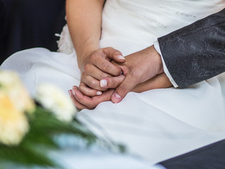 Hochzeits-Paar hält Händchen bei der Trauung