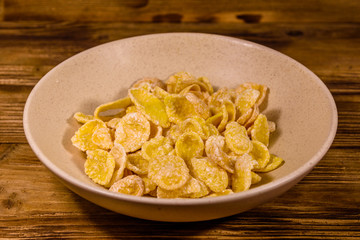 Ceramic plate with cornflakes on a wooden table. Healthy eating