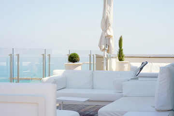 Interior of a large hotel balcony, villas. Beautiful balcony with white divans. White interior...