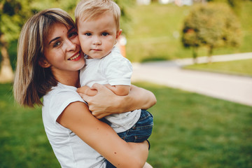 Fototapeta premium Family in a summer park. Mother in a white t-shirt. Cute little boy