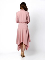 Young beautiful woman posing in new fashion casual pink winter dress smiling on white back view