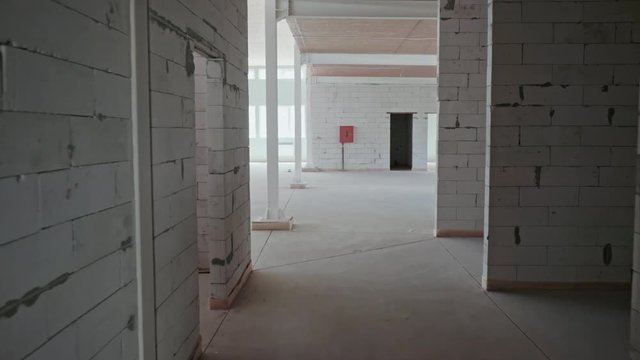 Under construction empty office space. The movement of the camera in the room, inspection of the interior. Empty large apartment with white walls in the new building in the process of repair. Plastic 