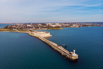Naklejka na ściany i meble Aerial view of Konstantinovskaya battery in Sevastopol Bay in Crimea. Sea landscape with coastline and cityscape on background
