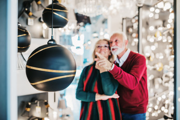 Senior couple in home lighting store shoosing shandelier for their home