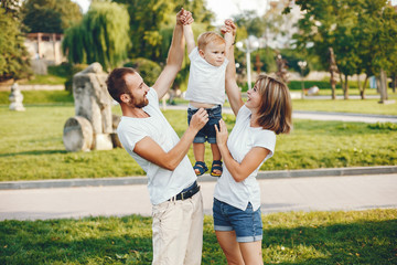 Obraz premium Family in a summer park. Mother in a white t-shirt. Cute little boy with a dad