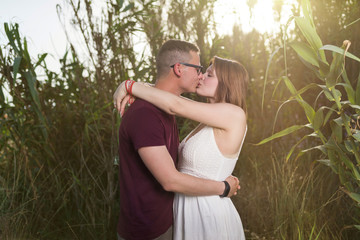 Happy moments together. Happy young couple embracing and kissing outdoors