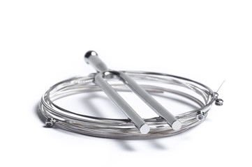 Rolled strings, tuning forks for guitar on white background