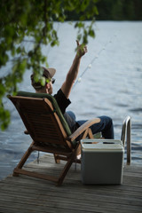 Mature man fishing from pier