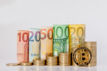 Bitcoin and Ten, twenty, fifty, one hundred, two hundred and coins euro rolled bills banknotes on white background. Histogram from the euro. Concept of currency growth, savings.