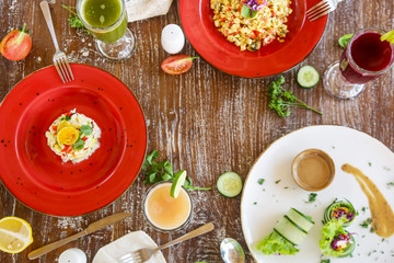 Healthy organic vegetarian dishes and glasses of detox drinks served on the restaurant table.	