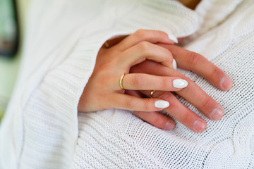 Circumcised shot of a young couple hugging, hands one on the other. Close-up of a young couple in nature warmed by a white blanket
