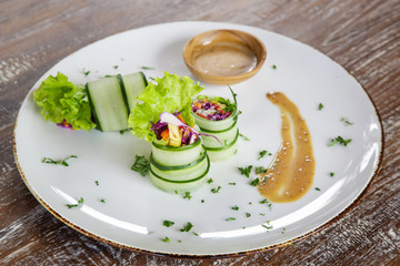 Thinly sliced raw zucchini rolls with veggies and peanut sauce, organic vegetarian healthy snack	