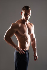 Strong, fit and sporty bodybuilder man over black background.