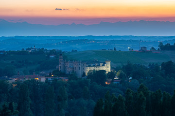 Naklejka premium Castle of Costigliole d'Asti (Piedmont - Italy). Sunset light view with white castle bright