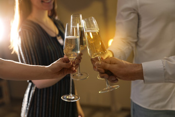 Friends clinking glasses of champagne at party, closeup