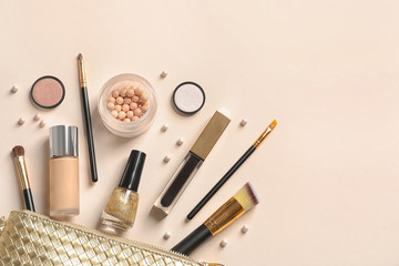 Cosmetic bag and different luxury makeup products on color background, flat lay. Space for text