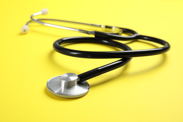 Stethoscope on color background, closeup. Medical tool