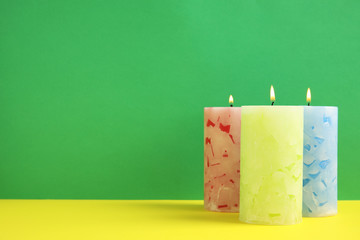 Alight wax candles on color background. Space for text
