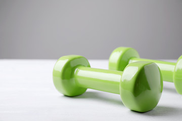 Obraz na płótnie Canvas Bright dumbbells on white table, space for text. Home fitness