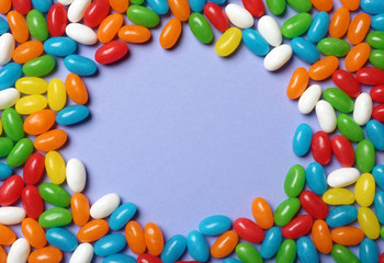 Fototapeta premium Frame made of bright jelly candies on color background, flat lay. Space for text