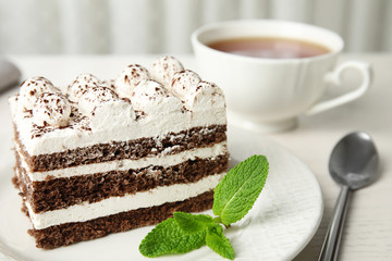 Tiramisu cake with cup on table, closeup. Space for text