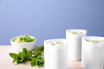 Kiwi yogurt on table against color background, space for text. Multi cooker recipe