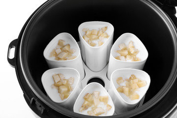 Cups of banana yogurt in multi cooker, closeup
