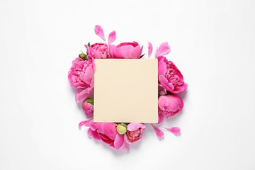 Fresh peonies and empty card on white background, top view with space for text