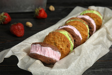 Different sweet delicious ice cream cookie sandwiches served on table