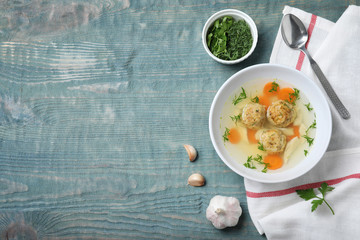 Flat lay composition with Jewish matzoh balls soup on wooden table. Space for text