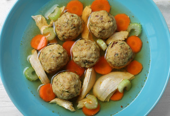Bowl of Jewish matzoh balls soup on table, closeup