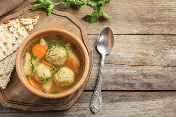 Flat lay composition with Jewish matzoh balls soup on wooden table. Space for text