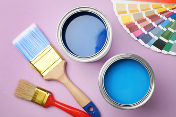 Flat lay composition with open cans of paint on color background