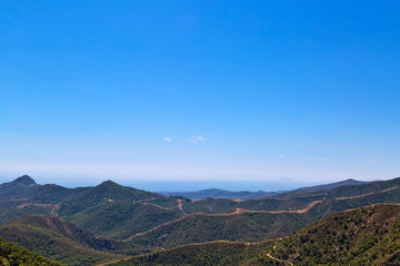 view of a beautiful hillside with the sea and mountains