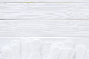 Menstrual period concept with sanitary pads on white wooden background top view copy space