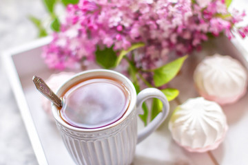 The tea served in a gift box with marshmallows and a bouquet of a lilac. Close up.