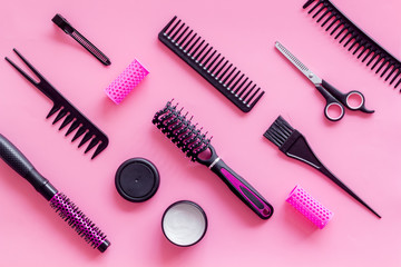 professional accessories of hairdresser with combs and sciccors on work desk pink background top view copyspace
