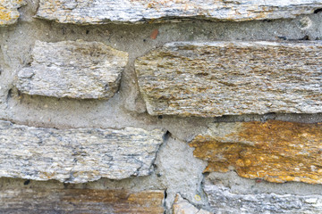 Full frame of Old beige stone wall background texture